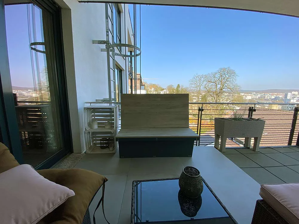 geflieste Terrasse mit Sitzbank und weitem Blick in die Natur