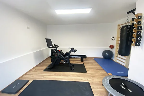 privater Fitnessraum mit eliTile Niedrigenergie Flächenheizmodulen im unteren Drittel der Wände verbaut.