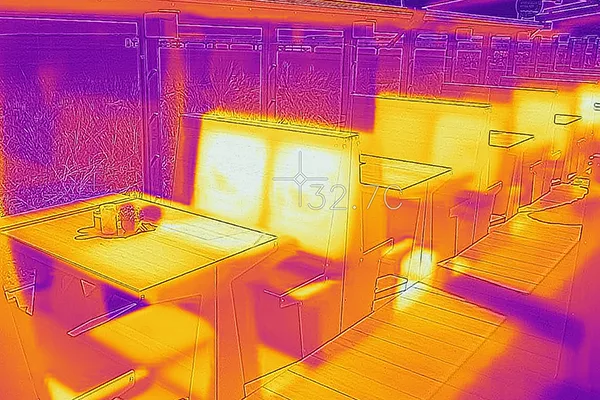 Infrarot-Aufnahme der Capolino Puro Lounge: Die Bänke, Tische und Bodenflächen sind wärmer als die Umgebung. Die Temperatur beträgt an den Flächen etwas über 30°C.