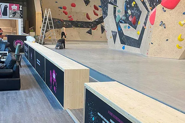 Sitzecke in einer Boulderhalle, an den Fensterfronten und den Raumtrennern befinden sich im unteren Bereich eliTile Großflächenheizungen. Diese können individuell bedruckt werden.